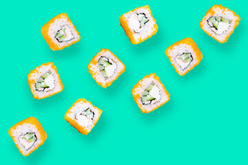 Rolls with crab meat and tobiko caviar on a green background. Leviation, top view, minimalism, pattern. Asian food concept.