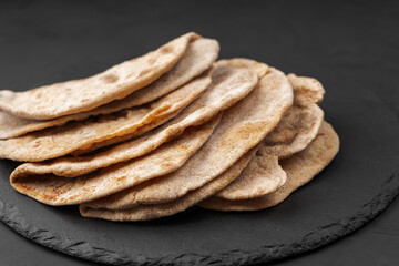 Flatbreads on a black slate Board