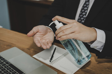 Coronavirus. young businessman in black suit hands washing with alcohol gel for clean corona virus (covid19) prevention, health care, virus outbreak protection, cleaning hand, self quarantine concept