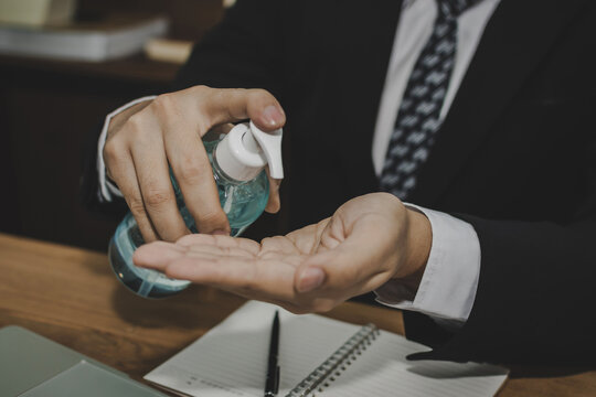 Coronavirus. young businessman in black suit hands washing with alcohol gel for clean corona virus (covid19) prevention, health care, virus outbreak protection, cleaning hand, self quarantine concept - Powered by Adobe