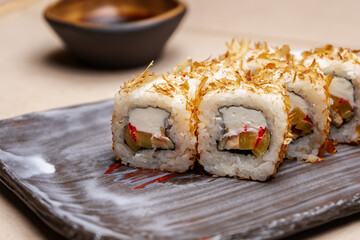 Bonito roll in tuna shavings on a sushi plate.