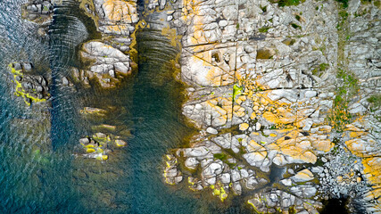 Graue Granit Küste in der Nähe der dänischen Stadt Svaneke auf Bornholm mit blauem Wasser der...