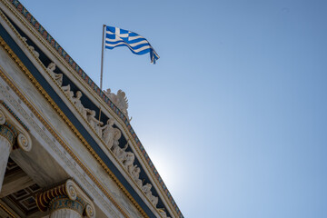 Greek flag flying over classic-styled building in Athens