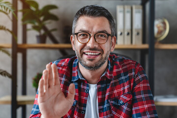 Middle aged man using video chat in office view from web camera