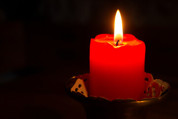 Beautiful illuminated red candle with still flame