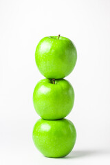Green apples on a white background. Three green apples stand on top of each other