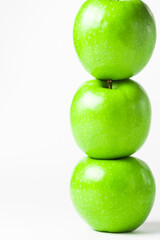 Green apples on a white background. Three green apples stand on top of each other