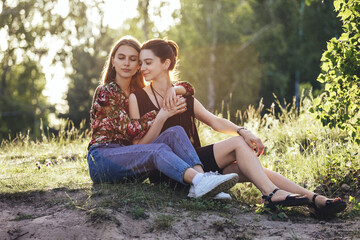 Young lesbian couple hugging at sunset outdoors