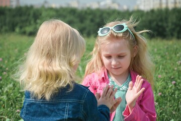 Two sisters play in the park on the grass