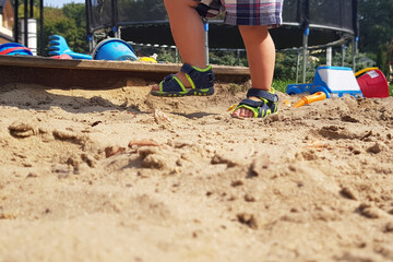 Little boy playing in the sand - close up photo of the sandy legs