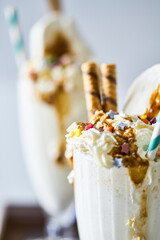 Milkshake with chocolate topping in a glass cocktail bowl, decorated with marshmallows