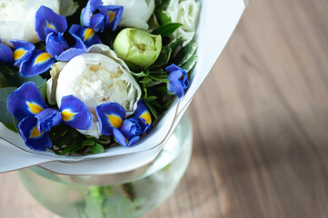 Peonies in a glass transparent vase. Selective focus. White and blue.