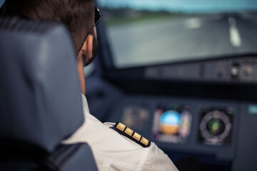 Young pilot in the aircraft in front of the dashboard. Pilot control airplane. Flight by commecial Airlines. Pre-flight preparation before the flight.Image with selestive focus.