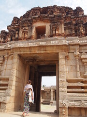 A woman strolls around inside a historic ruins, The Ruins of Hampi, Hampi, Karnataka, South India, India