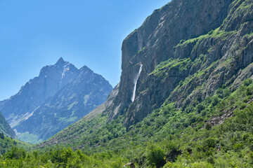 Fototapeta premium waterfall high in the mountains against the sky