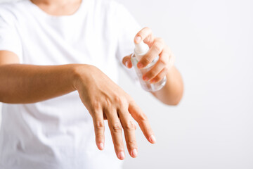 Closeup Hand Asian young woman applying spray pump dispenser sanitizer alcohol on back hand wash cleaning, hygiene prevention COVID-19 or coronavirus protection concept, isolated on white background
