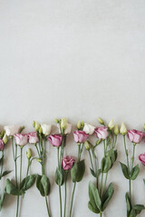 Flowers composition with many roses on grey background. Flat lay, top view festive holiday celebration