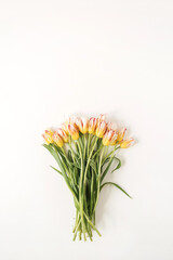 Yellow tulip flowers bouquet on white background. Flat lay, top view festive holiday celebration floral concept
