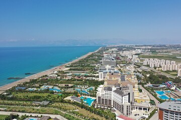 Sandy beaches of the Mediterranean. Kundu holiday complex with five star hotels. Beach, sea, water sports, parasailing, entertainment and shopping center. Aerial view with drone. Kundu, Lara -TURKEY