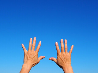 空に向けて広げた日本人男性の手