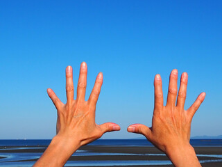 海に向けて広げた日本人男性の手