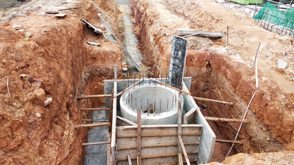 SEREMBAN, MALAYSIA -MARCH 10, 2020: Utility services manhole and underground pipes under construction at the construction site. In-situ construction by workers based on infrastructure engineer design.
