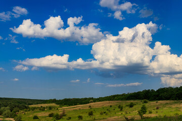 Spring landscape with green trees, meadows, fields and blue sky