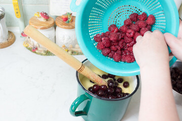 Preparation of cake with cherries and raspberries.