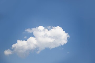 One white cloud floats on clear blue sky background