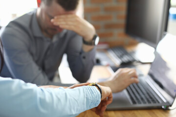 Close-up of director scolding employee for tardiness for work. Worker covering face with hand in shame. Office interior on background. Business deadline and lack of time concept