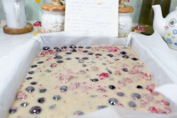 Preparation of cake with cherries and raspberries.