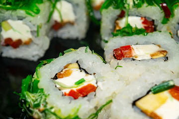 Rolls with fish, cheese and green algae. A traditional Japanese dish. Close up.