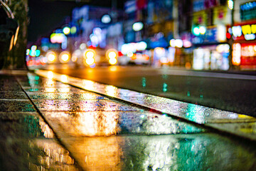 a photo of a sidewalk reflecting a headlight.