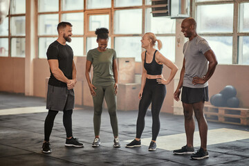 Diverse group of friends laughing together in a gym