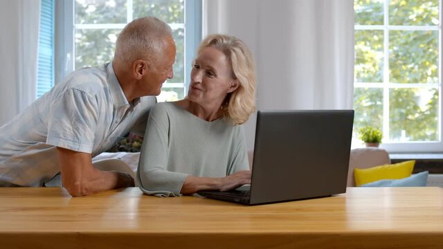 Elderly couple using laptop computer at home together