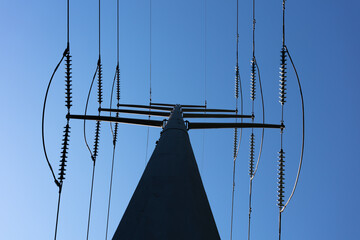 High Voltage Electric Power line on pole against bright blue sky