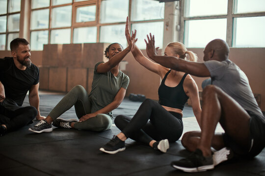 Diverse friends high-fiving after a gym workout class