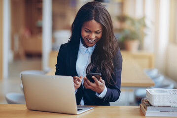 Laughing African American businesswoman reading a cellphone mess