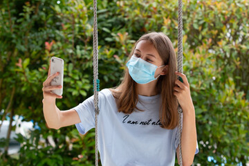 Fille avec un masque qui se prend en selfie 