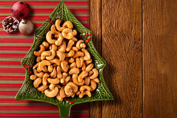 Cashew nut in a Christmas Tree Pot on a wood background. Top View.