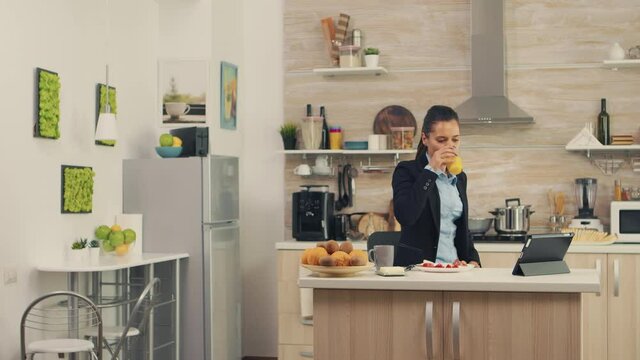 Woman hurrying up to finish breakfast while she's late at work. Young freelancer working around the clock to meet her goals, stressful way of life, hurry, late for work, always on the run