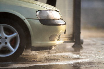 Car wash. The front of the car with dripping drops and trickles of water after a car wash. Close-up...