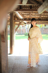 Portrait of Thai female with traditional Thai dress with temple background