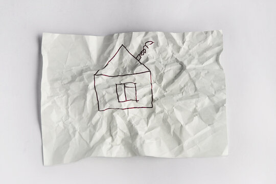 A Crumpled White A4 Sheet With A House Drawn On It. The Concept Of A Dream Of Your Own Home. 