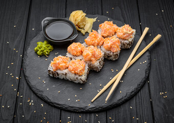 Sushi set nigiri and sushi rolls served on black stone slate