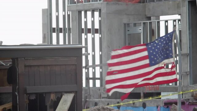 A tattered American flag waves in the wind after Hurricane Sandy batters the Brooklyn beachfront.