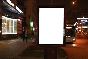 Advertising vertical billboard in the city glows at night. MOCKUP for design