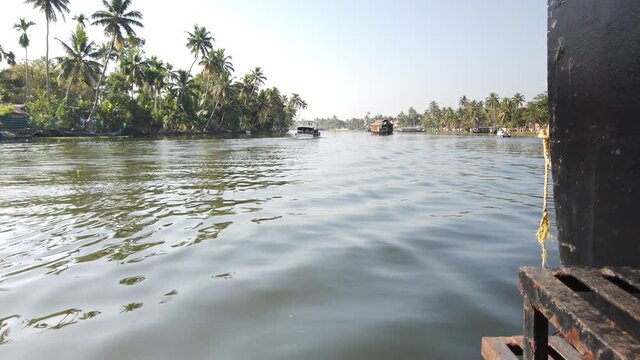 Low Shot of Waves, Boats and Palm Trees on Waterway at Alappuzha, Kerala, India