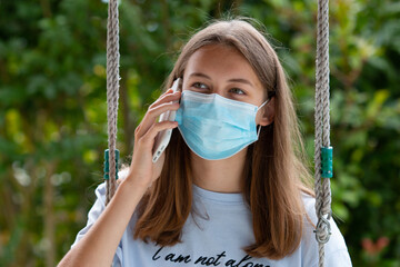 Fille avec un masque qui téléphone