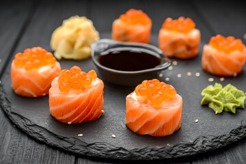 salmon sushi rolls on black background.